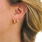 Girl wearing 3 18k gold filled huggie earrings 