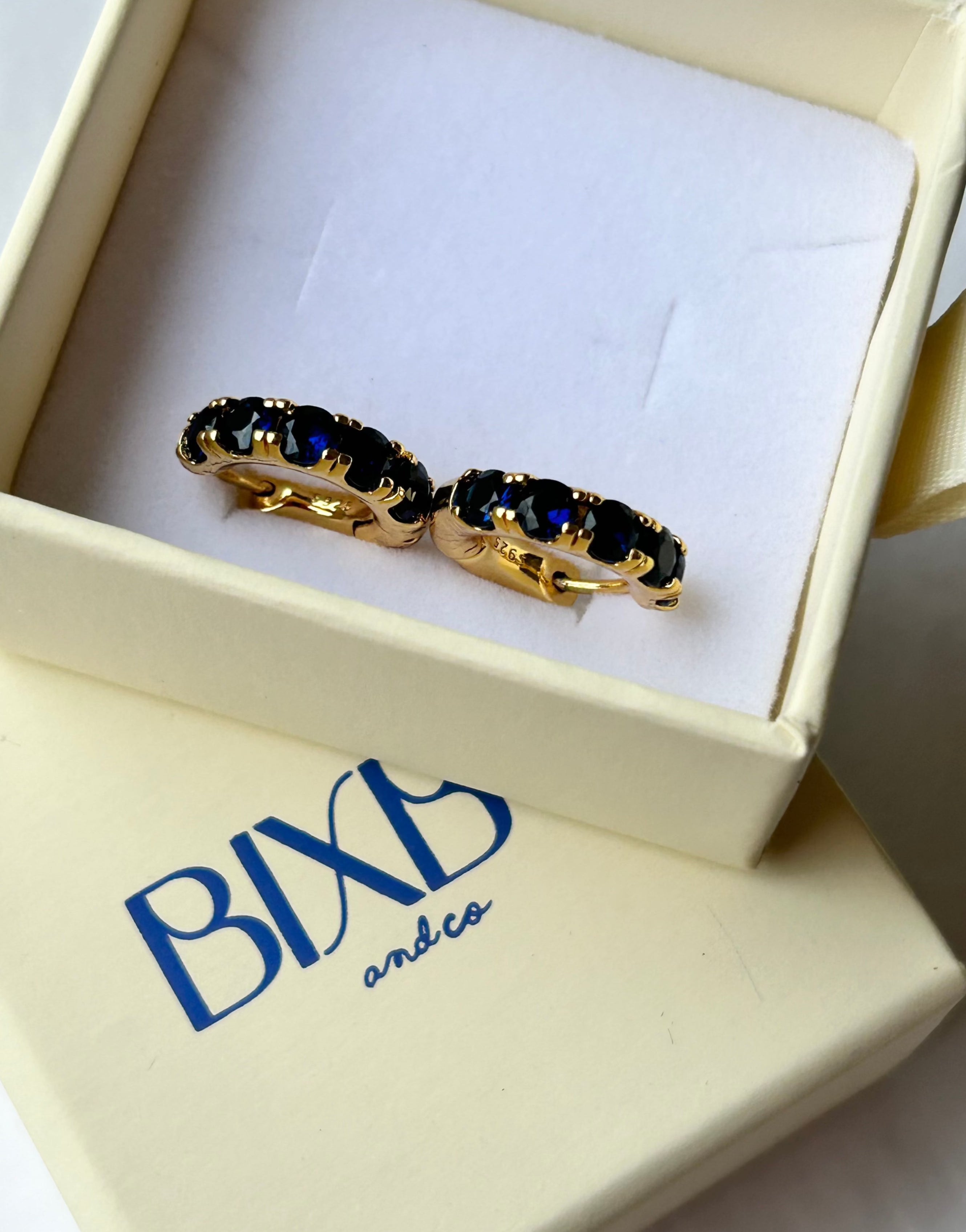 Sapphire blue crystal and gold huggies from Bixby and Co