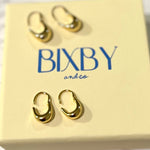 Bixby packaging with Noma earrings on in a flat lay